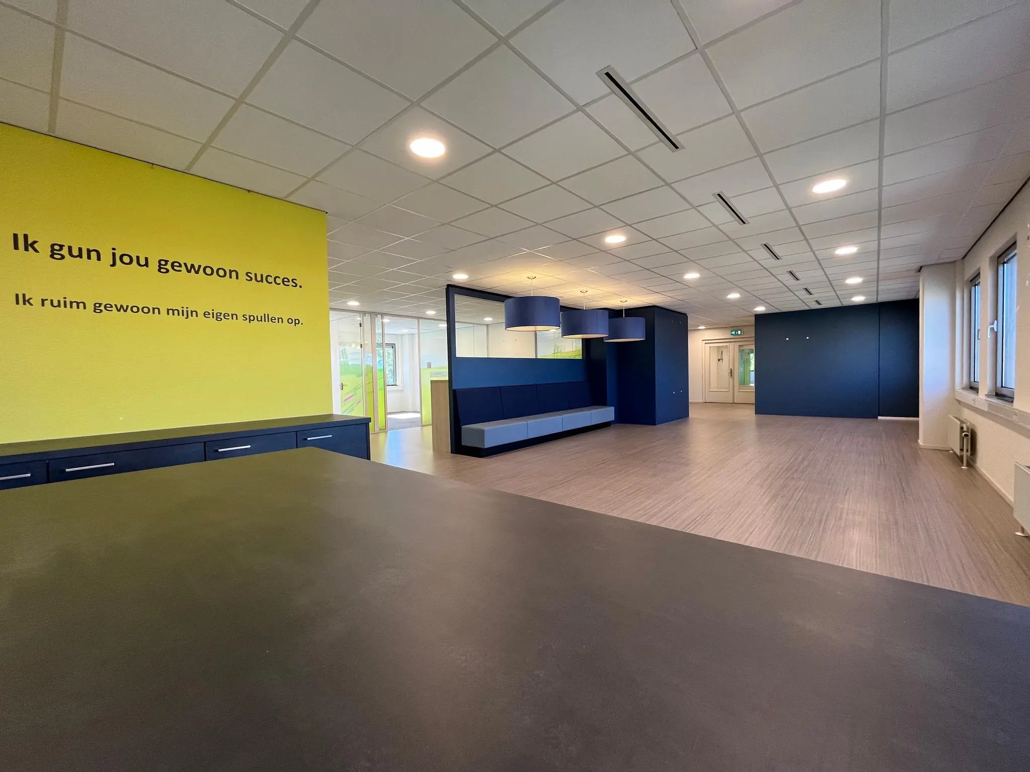 Moderne, ruim opgezette kantoorruimte aan de Barchman Wuytierslaan met een opvallende gele muur en motiverende tekst.